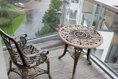 a table and a chair on a balcony at The Luxurious Semi-Circle in Cambridge