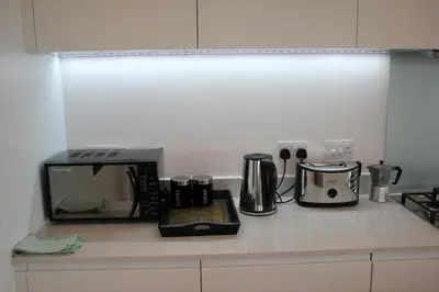 a kitchen counter with a coffee maker and a microwave at The Luxurious Semi-Circle in Cambridge