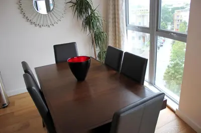 a dining room table with chairs and a vase on it at The Luxurious Semi-Circle in Cambridge
