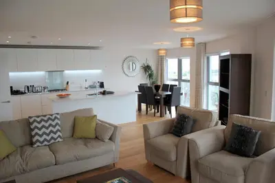 a living room with two couches and a kitchen at The Luxurious Semi-Circle in Cambridge