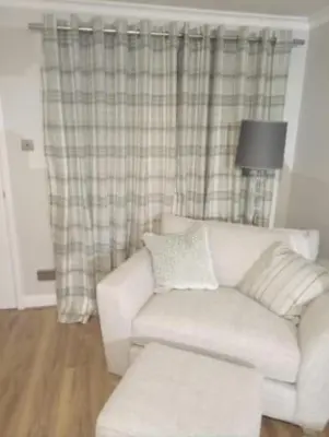 a living room with a white couch and a lamp at 2 Bedroom Garden Flat in Halesworth