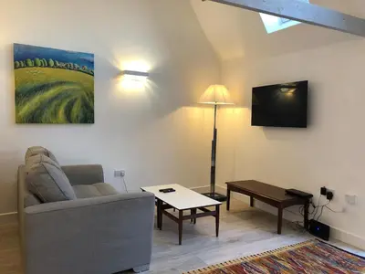 a living room with a couch and a tv at Perfitt Place in Bungay