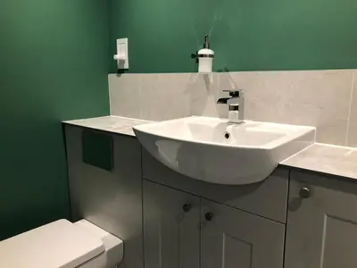 a bathroom with a white sink and a toilet at Perfitt Place in Bungay