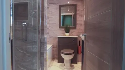 a bathroom with a toilet and a glass shower at Colchester Luxury Apartments - Colonia in Colchester
