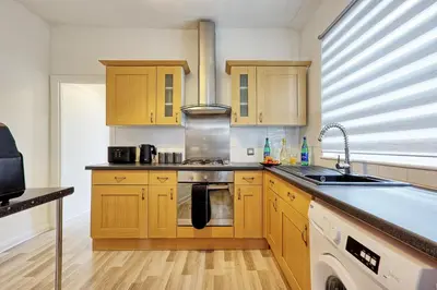a kitchen with wooden cabinets and a sink at Comfortable 2-Bedroom Home for 6, Perfect for Families, Contractors & Longer Stays, Clark Property Estates in Southend-on-Sea