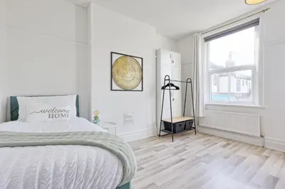 a white bedroom with a bed and a window at Comfortable 2-Bedroom Home for 6, Perfect for Families, Contractors & Longer Stays, Clark Property Estates in Southend-on-Sea