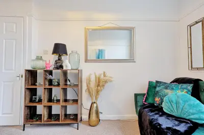 a living room with a couch and a mirror at Comfortable 2-Bedroom Home for 6, Perfect for Families, Contractors & Longer Stays, Clark Property Estates in Southend-on-Sea