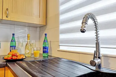 a kitchen with bottles and a sink with a bowl of fruit at Comfortable 2-Bedroom Home for 6, Perfect for Families, Contractors & Longer Stays, Clark Property Estates in Southend-on-Sea