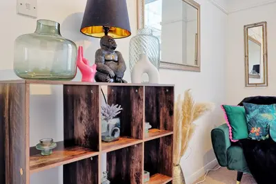 a living room with a wooden shelf with items on it at Comfortable 2-Bedroom Home for 6, Perfect for Families, Contractors & Longer Stays, Clark Property Estates in Southend-on-Sea