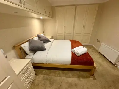 a bedroom with a large bed with pillows on it at Richard guest house in Roydon