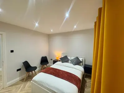 a bedroom with a bed and two chairs in it at Richard guest house in Roydon