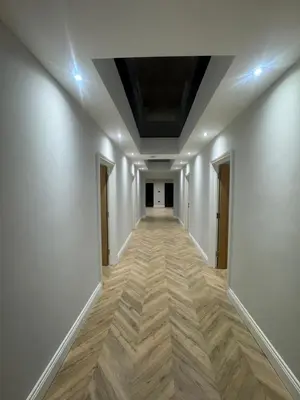 an empty hallway with white walls and wooden floors at Richard guest house in Roydon