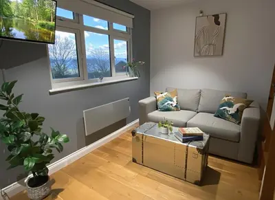 a living room with a couch and a table at Stylish self contained city apartment in Milton