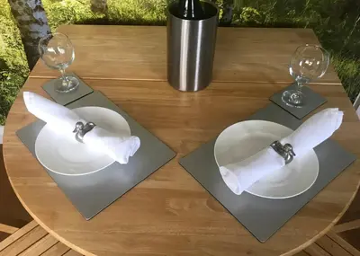 a table with two glasses and a plate with a bow tie at Stylish self contained city apartment in Milton