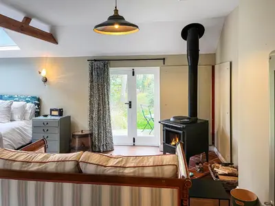 a living room with a couch and a wood stove at The Butterchurn - Uk50805 in Halesworth