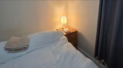 a bedroom with a bed with a lamp on a night stand at Cozy Guest Room in Colchester - Perfect for Travelers in Colchester