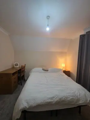 a bedroom with a large white bed and a desk at Cozy Guest Room in Colchester - Perfect for Travelers in Colchester