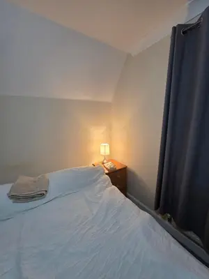 a bedroom with a bed and a lamp on a night stand at Cozy Guest Room in Colchester - Perfect for Travelers in Colchester