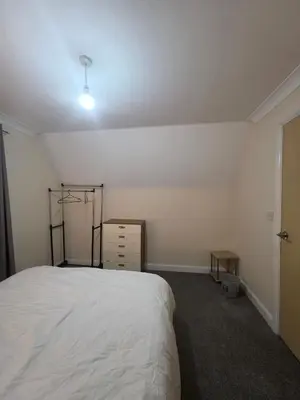 a bedroom with a bed and a dresser in it at Cozy Guest Room in Colchester - Perfect for Travelers in Colchester