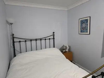 a bedroom with a bed with white sheets at Guest Room in Colchester Hythe in Colchester