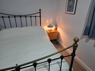 a bedroom with a bed and a lamp on a night stand at Guest Room in Colchester Hythe in Colchester