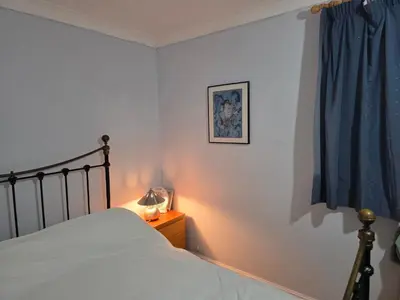a bedroom with a bed and a blue curtain at Guest Room in Colchester Hythe in Colchester