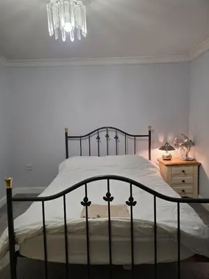 a bedroom with a bed and a chandelier at Near Colcheste town centre in Colchester