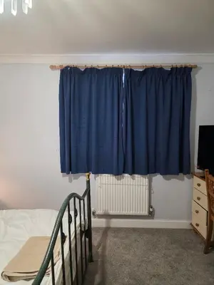 a bedroom with a blue curtain and a bed at Near Colcheste town centre in Colchester