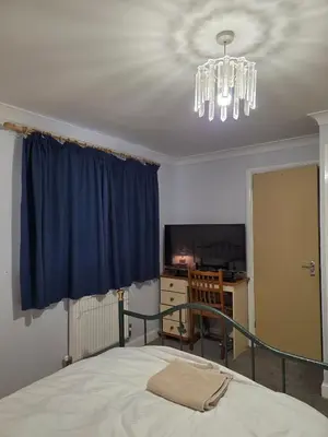 a bedroom with a bed and a chandelier at Near Colcheste town centre in Colchester