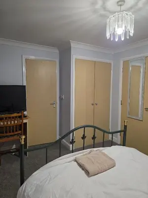 a bedroom with a bed and a chandelier at Near Colcheste town centre in Colchester