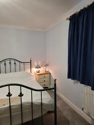 a bedroom with a bed and a lamp on a night stand at Near Colcheste town centre in Colchester