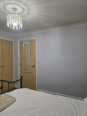 a bedroom with a white bed and a chandelier at Near Colcheste town centre in Colchester