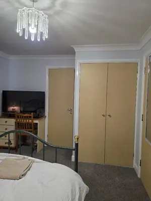 a bedroom with a bed and a chandelier at Near Colcheste town centre in Colchester