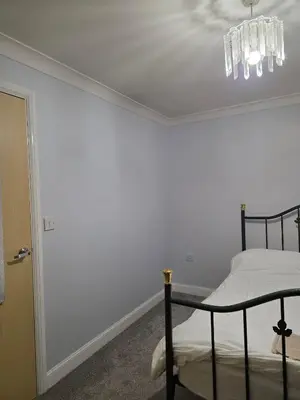 a bedroom with a bed and a chandelier at Near Colcheste town centre in Colchester