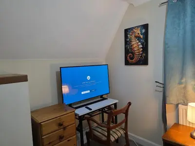 a television sitting on a desk with a chair at Charming Colchester Room with Garden Views in Colchester