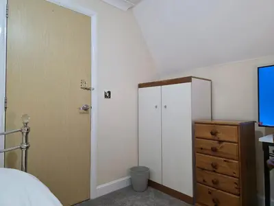 a bedroom with a bed and a closet and a dresser at Charming Colchester Room with Garden Views in Colchester