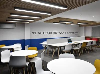 a classroom with white tables and yellow chairs at For Students Only - Student Castle Cambridge in Cambridge
