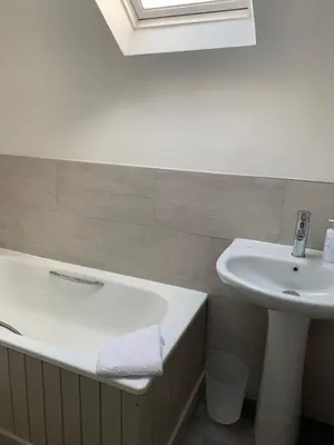 a bathroom with a sink and a bath tub at Bell Cottage in Mildenhall