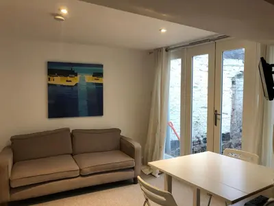 a living room with a couch and a table at Bell Cottage in Mildenhall