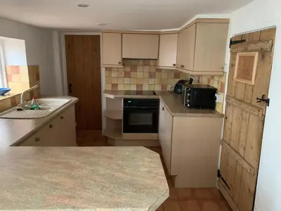 a small kitchen with a sink and a stove at Bell Cottage in Mildenhall