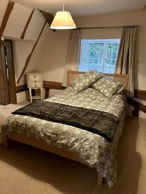 a bedroom with a bed and a window at Beautiful Cottage opposite Hedingham Castle! in Castle Hedingham