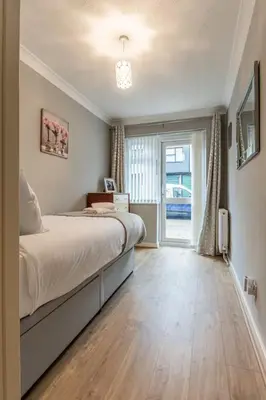 a bedroom with a large bed and a sliding glass door at Pass the Keys Seaside Escape 2-Bedroom Flat EastBeach sleeps 4 in Southend-on-Sea