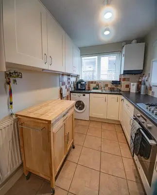 a kitchen with white cabinets and a counter top at Pass the Keys Seaside Escape 2-Bedroom Flat EastBeach sleeps 4 in Southend-on-Sea
