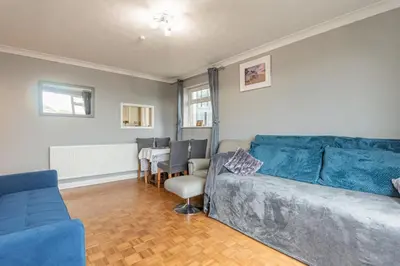 a living room with a blue couch and a table at Pass the Keys Seaside Escape 2-Bedroom Flat EastBeach sleeps 4 in Southend-on-Sea
