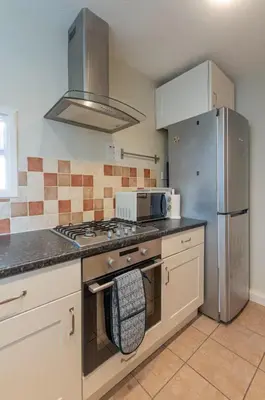 a kitchen with a stove and a refrigerator at Pass the Keys Seaside Escape 2-Bedroom Flat EastBeach sleeps 4 in Southend-on-Sea