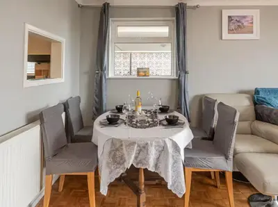 a dining room with a table and chairs and a couch at Pass the Keys Seaside Escape 2-Bedroom Flat EastBeach sleeps 4 in Southend-on-Sea