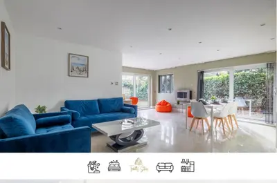 a living room with a blue couch and a table at 4 BR I 2 BA I Sleeps 8 I Spacious I Modern I Wi-Fi I in Cambridge