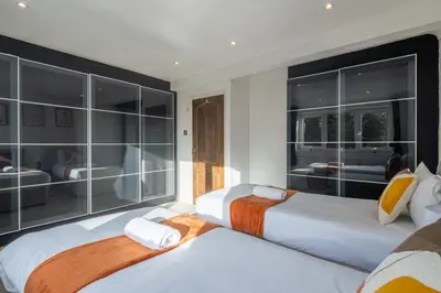 two beds sitting in a room with windows at 4 BR I 2 BA I Sleeps 8 I Spacious I Modern I Wi-Fi I in Cambridge