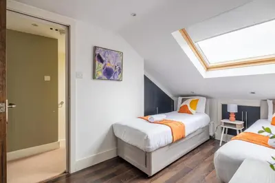 a attic bedroom with two beds and a skylight at 4 BR I 2 BA I Sleeps 8 I Spacious I Modern I Wi-Fi I in Cambridge