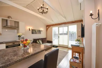 a kitchen and living room with a large counter top at The Barn in Little Maplestead